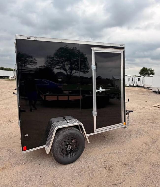 Black 5 by 8 single-axle enclosed cargo trailer with a side access door